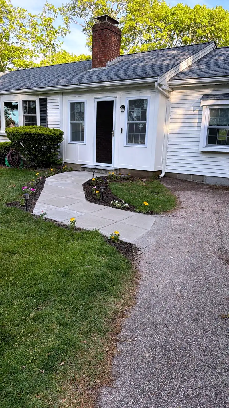 New front walkway leading to the entry of a white house