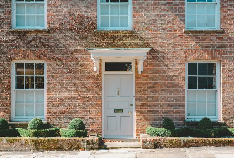 Brick house facade with a white front door and white-framed windows
