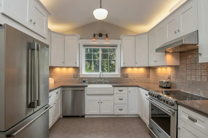 White kitchen with shaker cabinets, farmhouse sink and pendant light